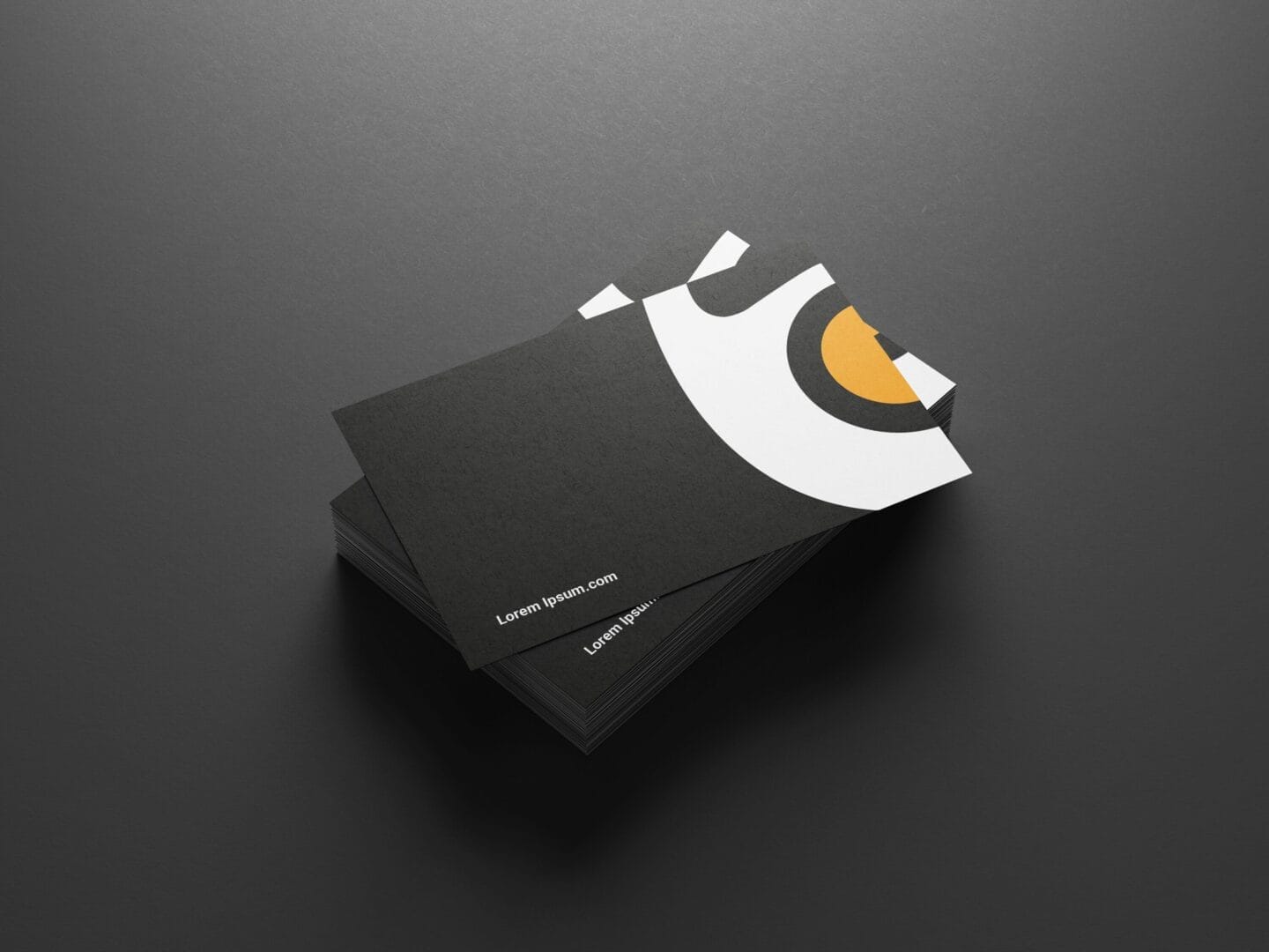 A stack of dark business cards with a minimalist design featuring a white curve and a yellow semicircle. The text reads 