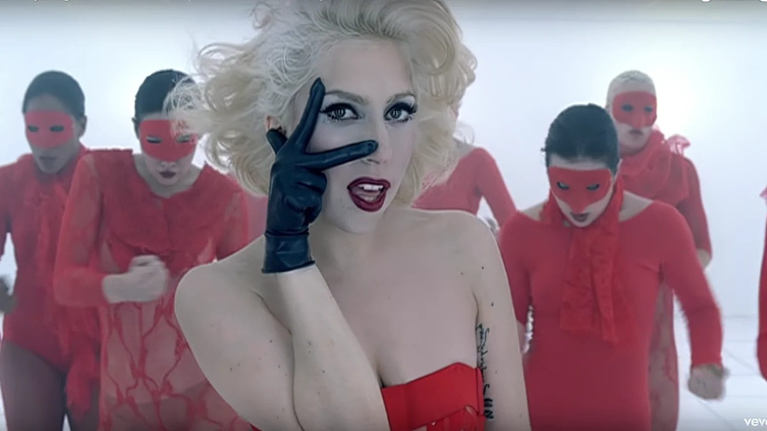 Most viewed videos on YouTube for each year (from 2005 to today) A woman in black gloves poses with her hand over her eye, surrounded by dancers in red dresses and YouTube chart masks.