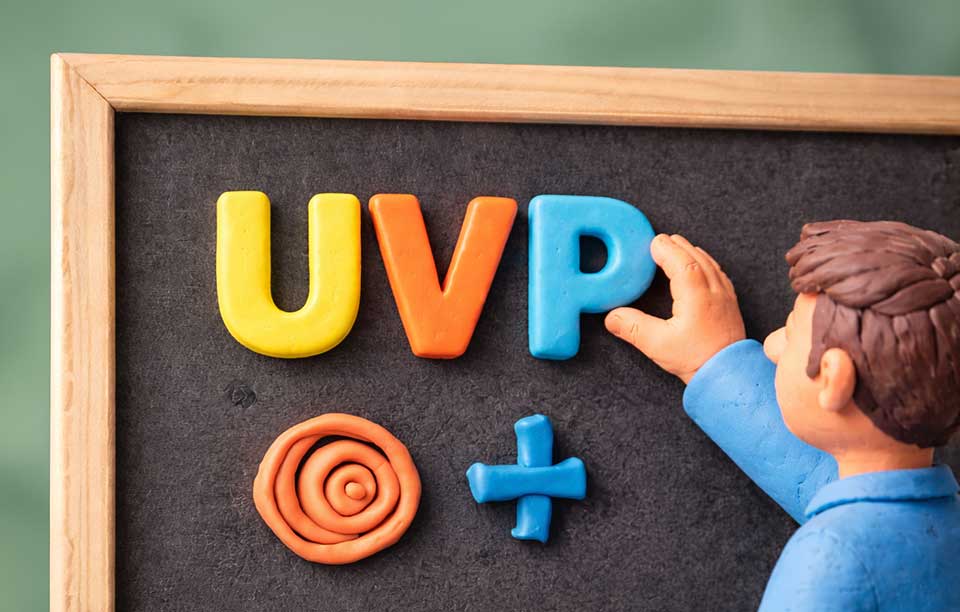 Unique Value Proposition (UVP): What It Is and How to Build It to Stand Out A clay figure displays the UVP-Unique Value Proposition on a chalkboard, with spiral symbols and a plus sign underneath.